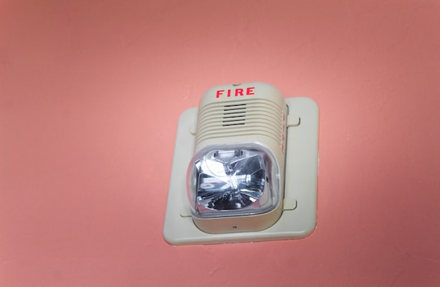 white%20fire%20alarm%20mounted%20on%20a%20pink%20wall white%20fire%20alarm%20mounted%20on%20a%20pink%20wall